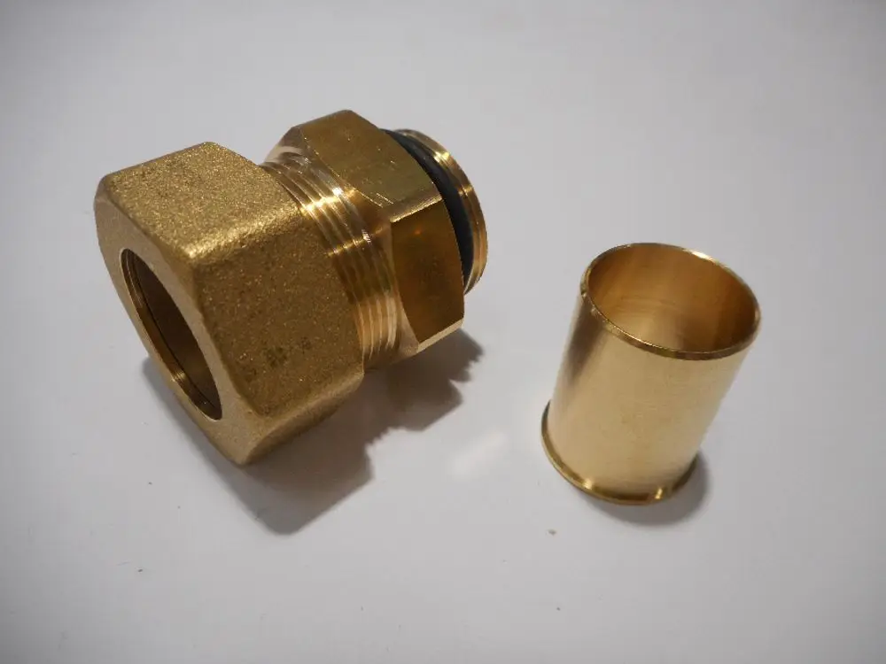 Goldfarbene Verbindungsteile aus Messing, darunter eine Verschraubung mit Gummidichtung und ein Rohrstück, möglicherweise von der Marke Remeha.
